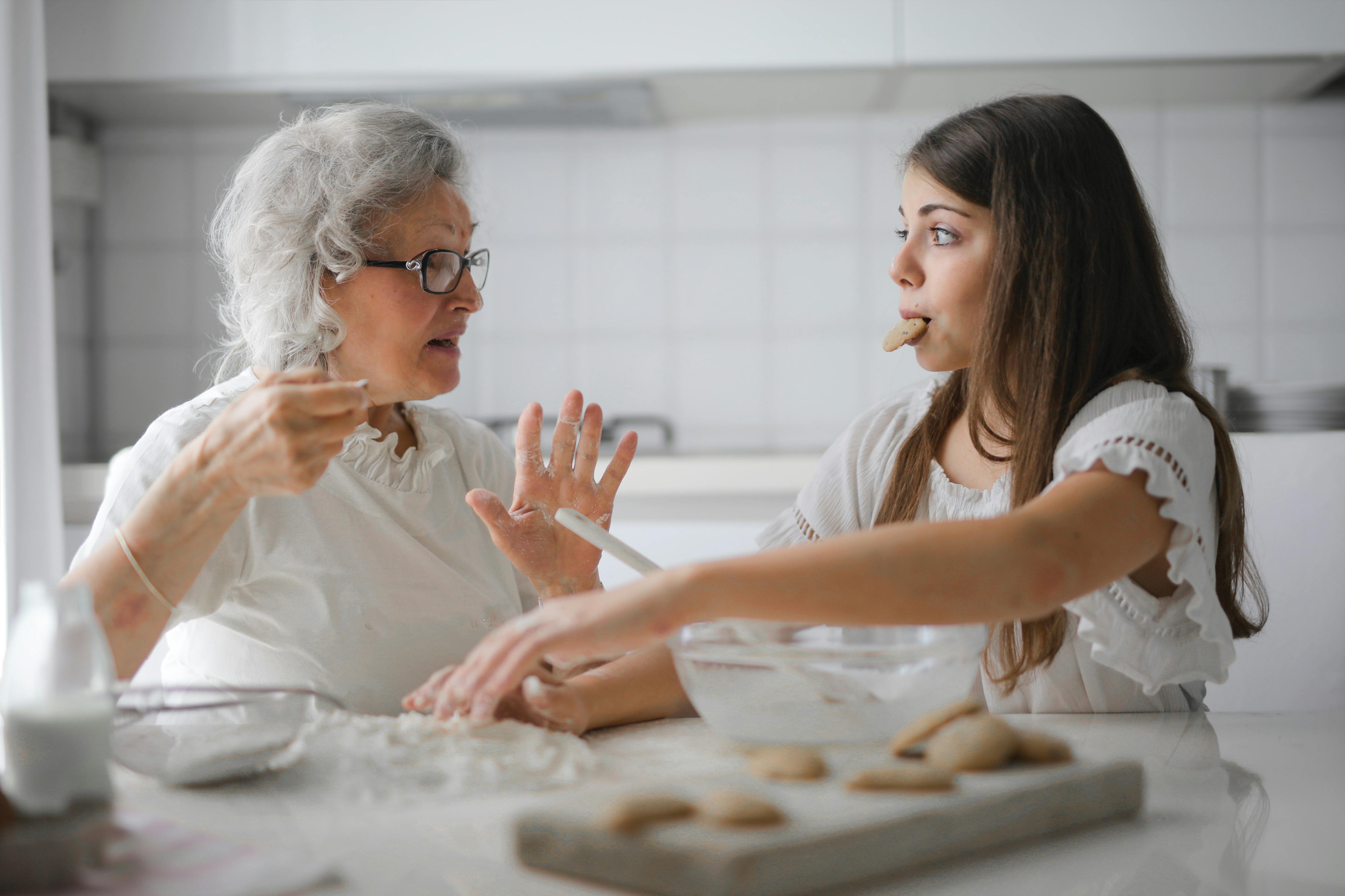 Ein Kind und eine Seniorin backen Kekse